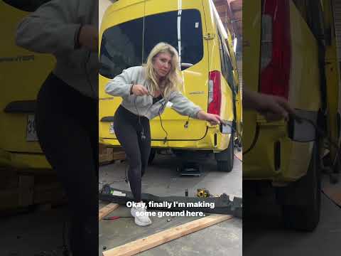 Blonde girl installs a bumper on 4x4.
