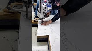 Cutting layered fabric patterns using an industrial vertical blade machine for precise production