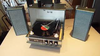 Motorola stereo solid state portable record player playing an LP record.