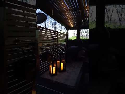 Custom steel garden pergola with wood fired pizza oven and table, built around a tree.