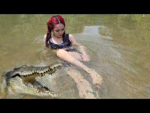 cameraPretty girl goes camping and grills fish in the stream