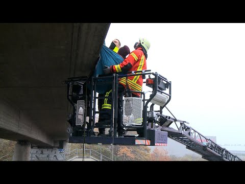 Aktivisten hängen an Autobahnbrücke - Feuerwehr und Polizei holen Personen von Brücke