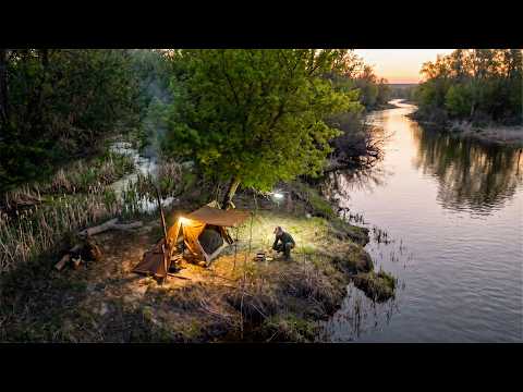 Solo hot tent camping by the river, The shore is teeming with fish