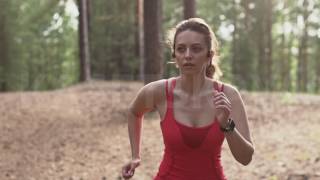 young woman preparing to jog, starts a workout tracking on a smart watch