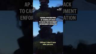 Federal officers push AP journalists back to car as they document enforcement operation