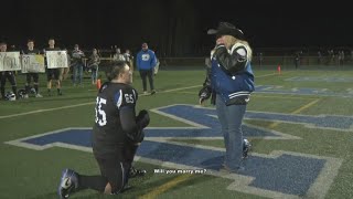 High school football player surprises girlfriend by proposing on field after senior night win